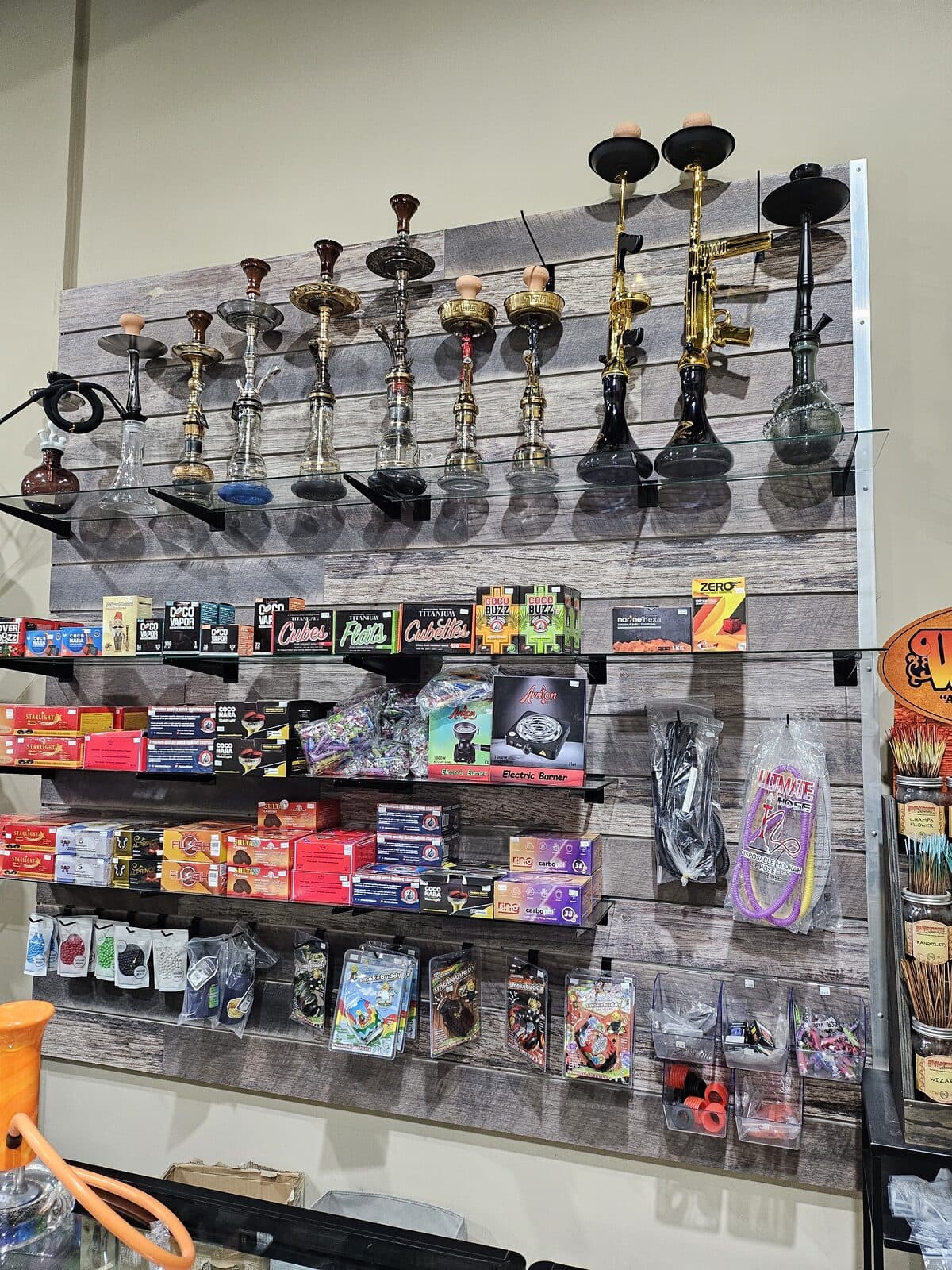Hookah wall with shisha, coals, hoses, and accessories at 3 Heads Smoke Shop in Elgin